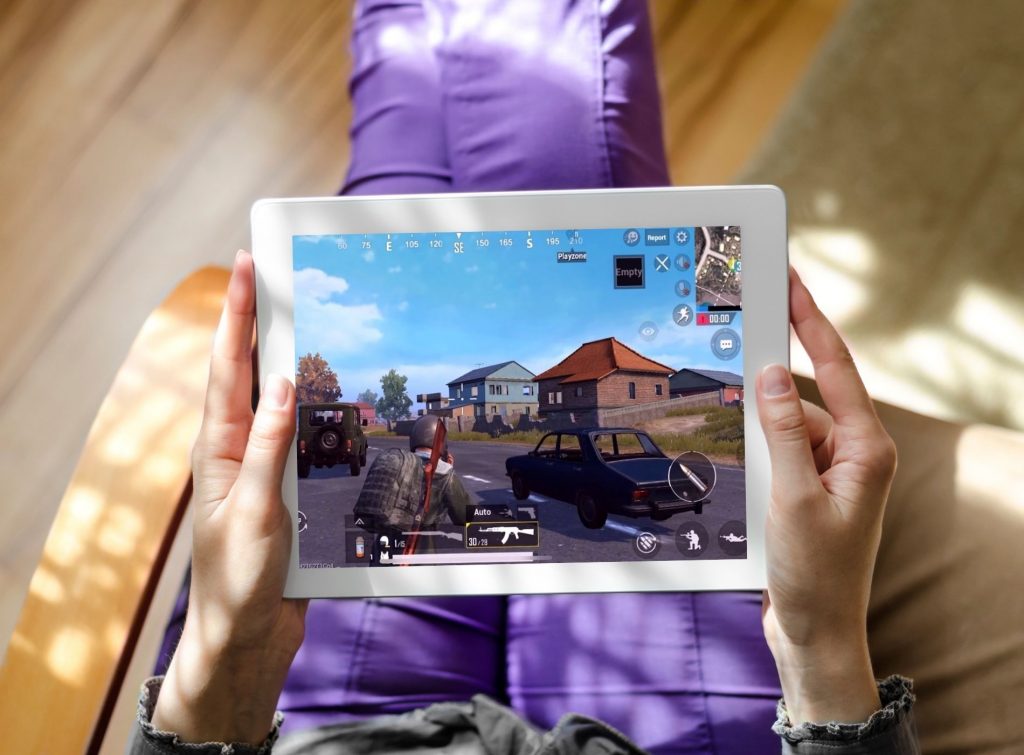 Persona recostada en su casa jugando en su tablet gaming al PUBG